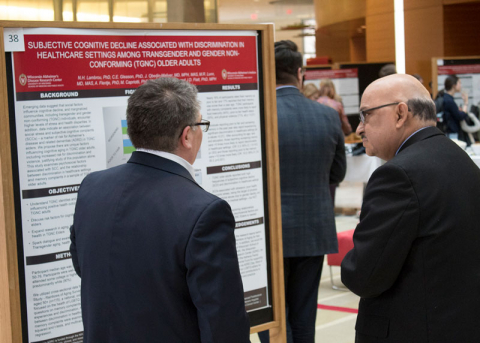 scientists talking in front of a research poster
