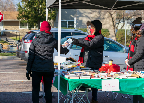 women handing out books