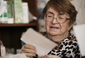 elderly woman opening letter