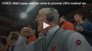 sports announcer matt lepay wearing a headset and cheering at a Wisconsin Badgers basketball game