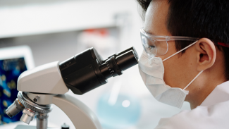 Stock photo of a man looking through a microscopt