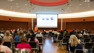 An audience watches as Dr. Julie Schneider gives a presentation at ADRD Research Day 2025