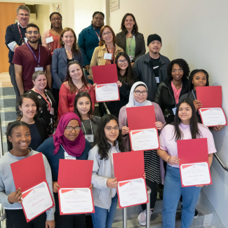 group photo of scientists and students holding participation certificates