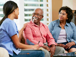 nurse speaking with elderly man and woman