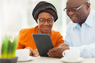 two elderly people looking at a tablet computer