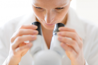 woman looking into a microscope