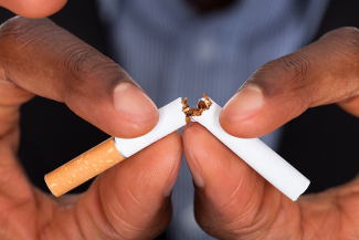 human hands breaking cigarette in half