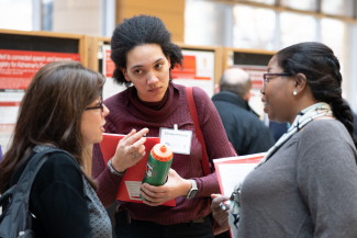 three women talking at a scientific conference