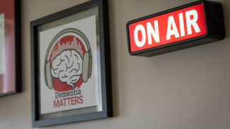 On Air sign lit up next to a framed photo of the 'Dementia Matters' logo