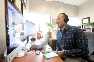 Photo of Dr. Nathaniel Chin at his computer speaking into a microphone
