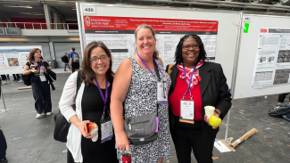 Dr. Kim Mueller, Amy Hawley, and Gina Green-Harris stand in front of a scientific poster at the Alzheimer's Association International Conference