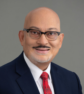 Headshot of Dr. Sanjay Asthana with grey background.