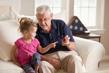 grandfather showing granddaughter military medal