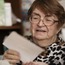 elderly woman reading piece of mail