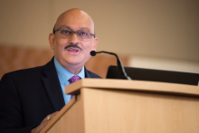 Sanjay Asthana MD at a podium speaking into a microphone