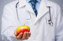 doctor in a white coat holding an apple