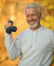 Stock photo of a man exercising with two small weights in his hand