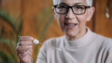 Stock photo of a woman inserting a swab into a test tube