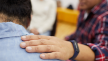 Stock photo of a person with their hand on the shoulder of another person