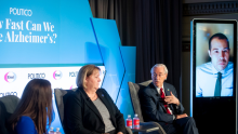 A photo of a panel at the POLITICO 'How Fast Can We Cure Alzheimer's' event. From left to right, POLITICO FDA reporter Laura Gardner, Gerontological Society of America representative Karen Tracy, UsAgainstAlzheimer's co-founder George Vrandenburg and Dr. Nathaniel Chin (shown virtually on a screen)