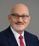 Headshot of Dr. Sanjay Asthana with grey background.